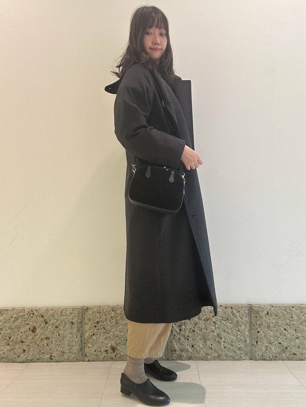 グレー系のニット/セーター、ブラック系のショルダーバッグ、ブラック系のその他シューズを着用したレディースの秋コーディネートの4枚目の写真