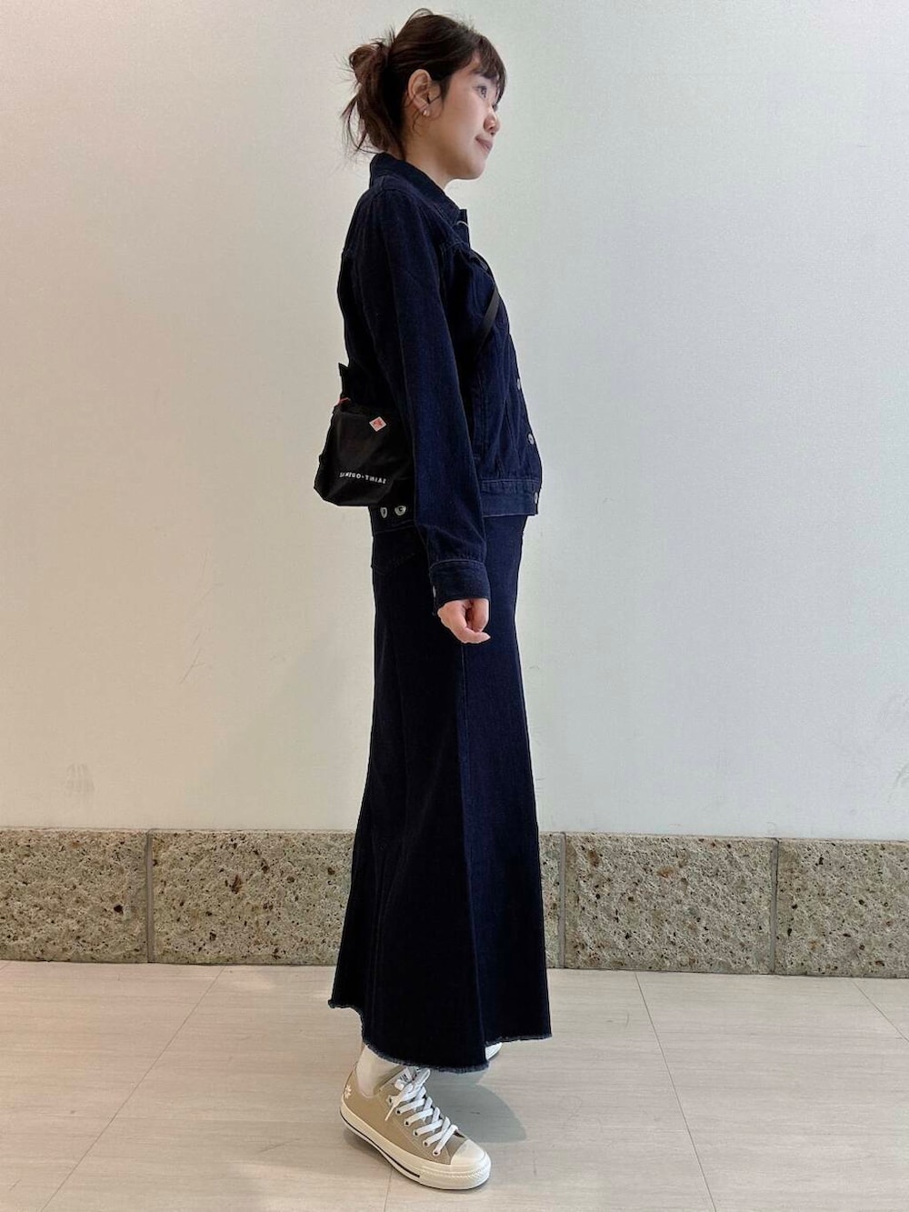 ブラック系のワンピース、ブルー系のスカート、ブルー系のデニムジャケットを着用したレディースの冬コーディネートの2枚目の写真