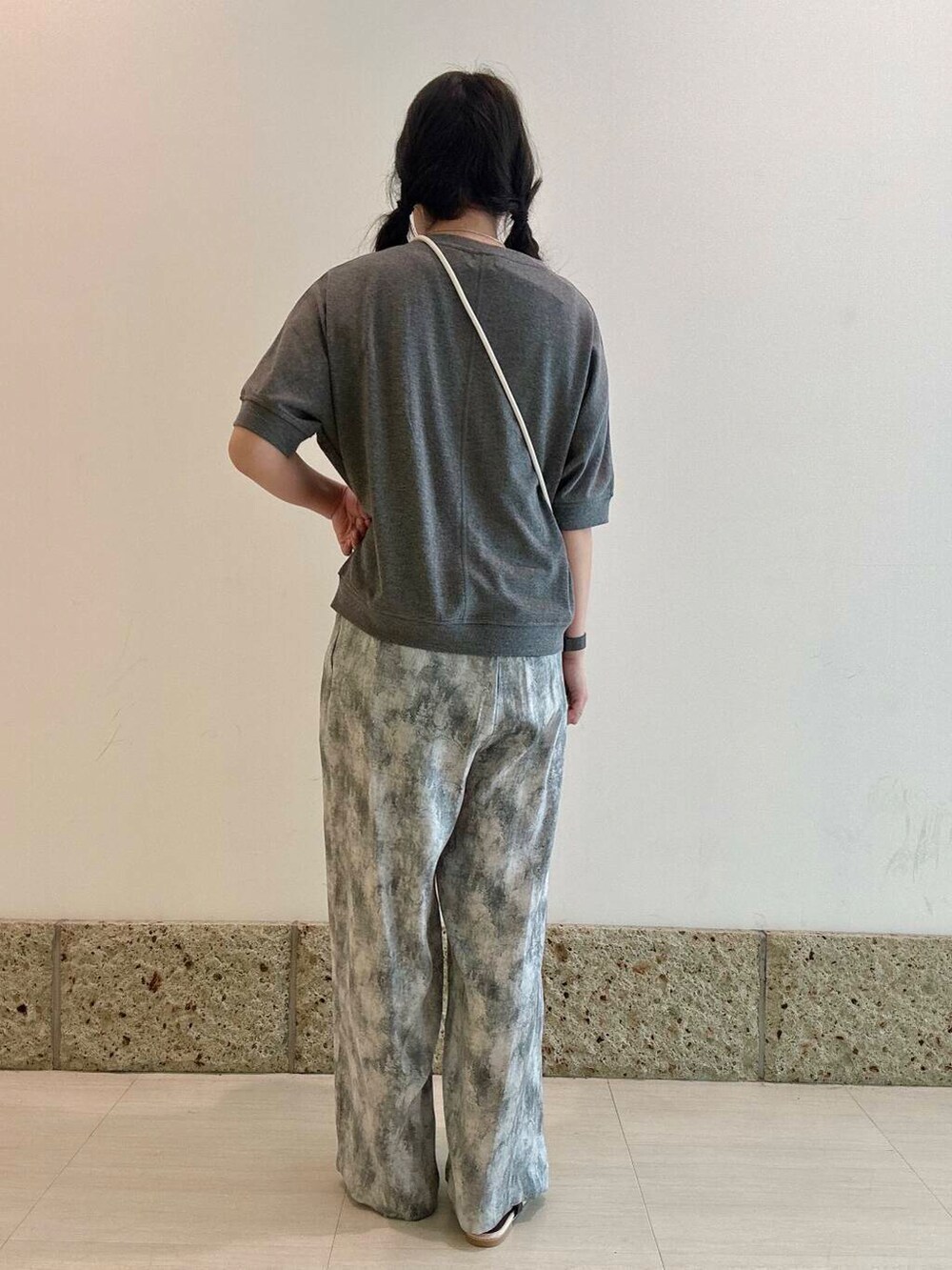 イエロー系のショルダーバッグ、ブラウン系のサンダル、グレー系のTシャツ/カットソーを着用したレディースの夏コーディネートの4枚目の写真