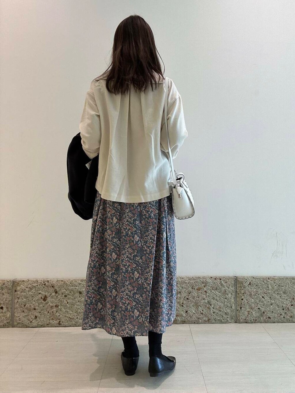 ブラック系のローファー、ブルー系のその他アウター、ホワイト系のショルダーバッグを着用したレディースの冬コーディネートの4枚目の写真