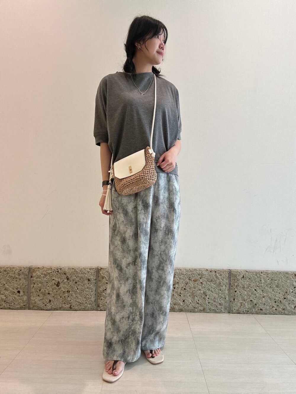 イエロー系のショルダーバッグ、ブラウン系のサンダル、グレー系のTシャツ/カットソーを着用したレディースの夏コーディネートの2枚目の写真