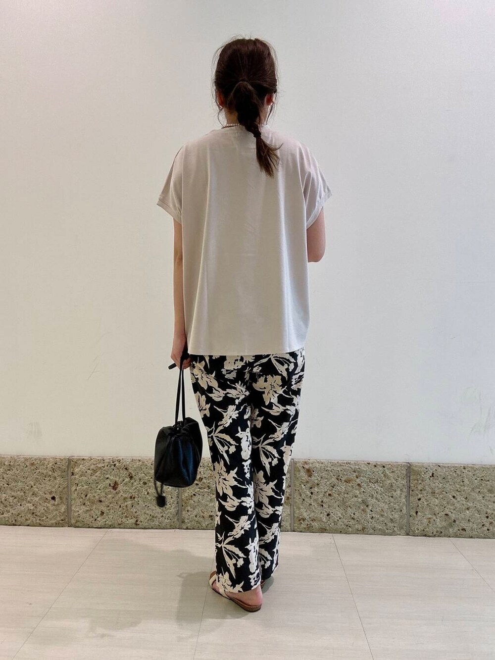 ブラック系のショルダーバッグ、ブラック系のその他パンツ、グレー系のTシャツ/カットソーを着用したレディースの夏コーディネートの3枚目の写真