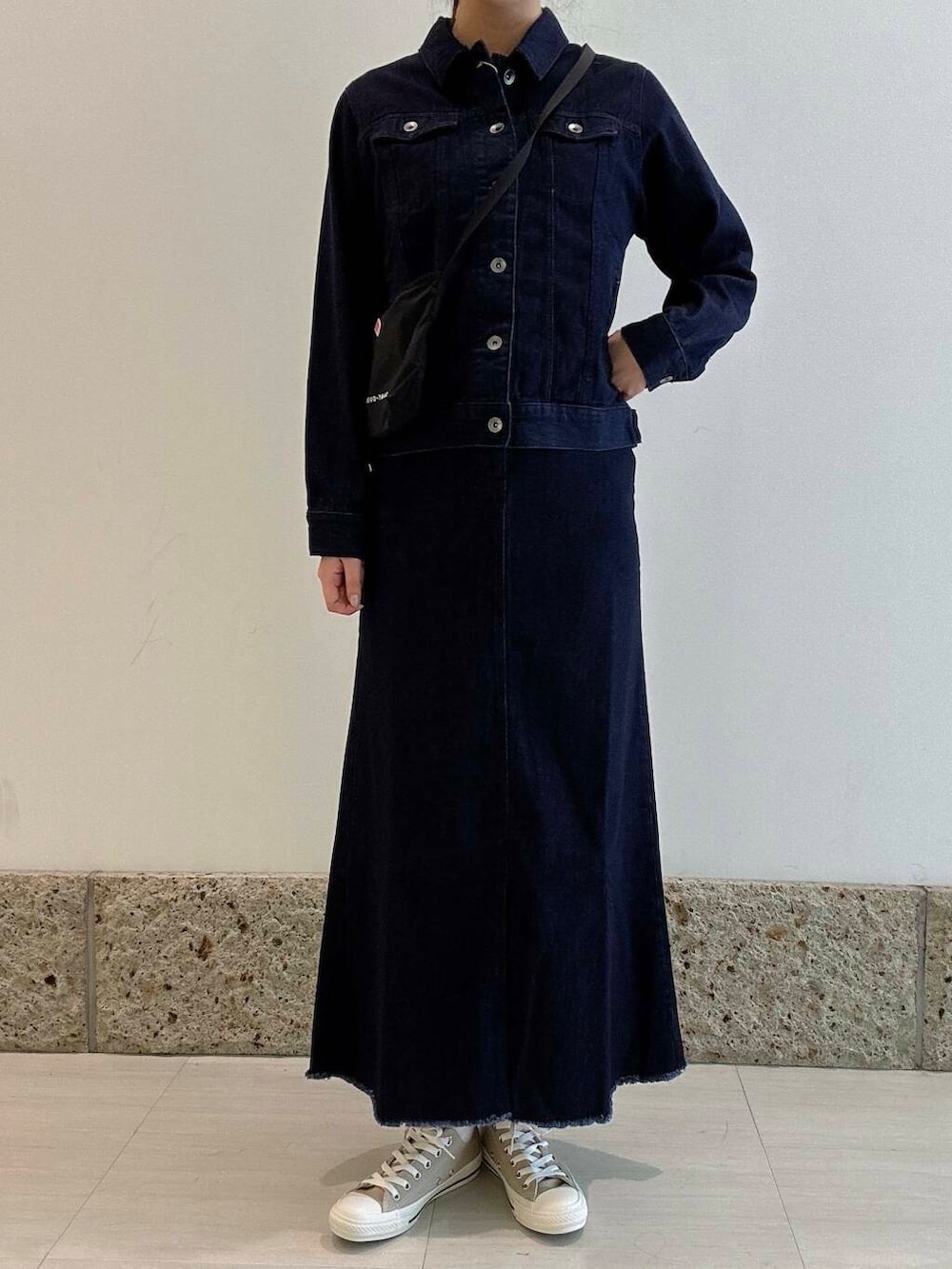 ブラック系のワンピース、ブルー系のスカート、ブルー系のデニムジャケットを着用したレディースの冬コーディネートの4枚目の写真