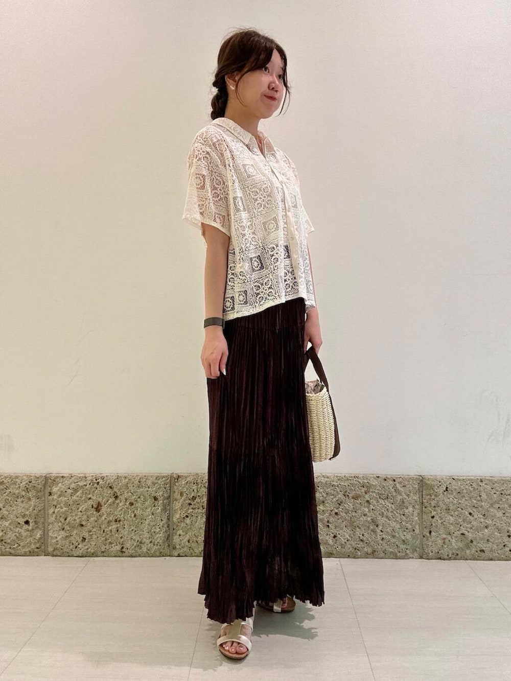 ホワイト系のハンドバッグ、ホワイト系のタンクトップ、ブラウン系のスカートを着用したレディースの夏コーディネートの2枚目の写真