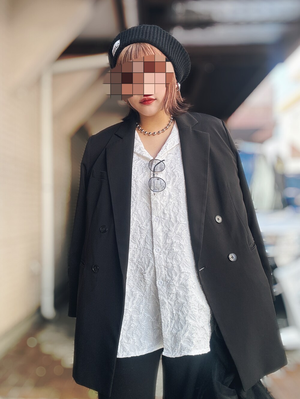 ブラック系のテーラードジャケット、ホワイト系のシャツ/ブラウス、ブラック系のショルダーバッグを着用したレディースの秋コーディネートの2枚目の写真