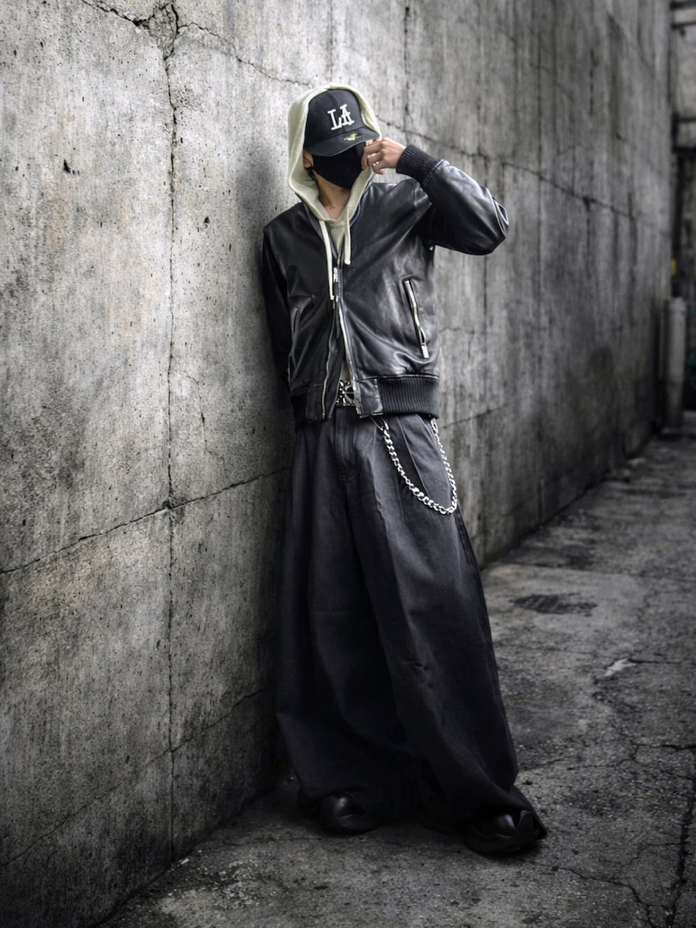 ブラック系のデニムパンツ、ベージュ系のパーカー、ブラック系のMA-1を着用したメンズの冬コーディネートの2枚目の写真