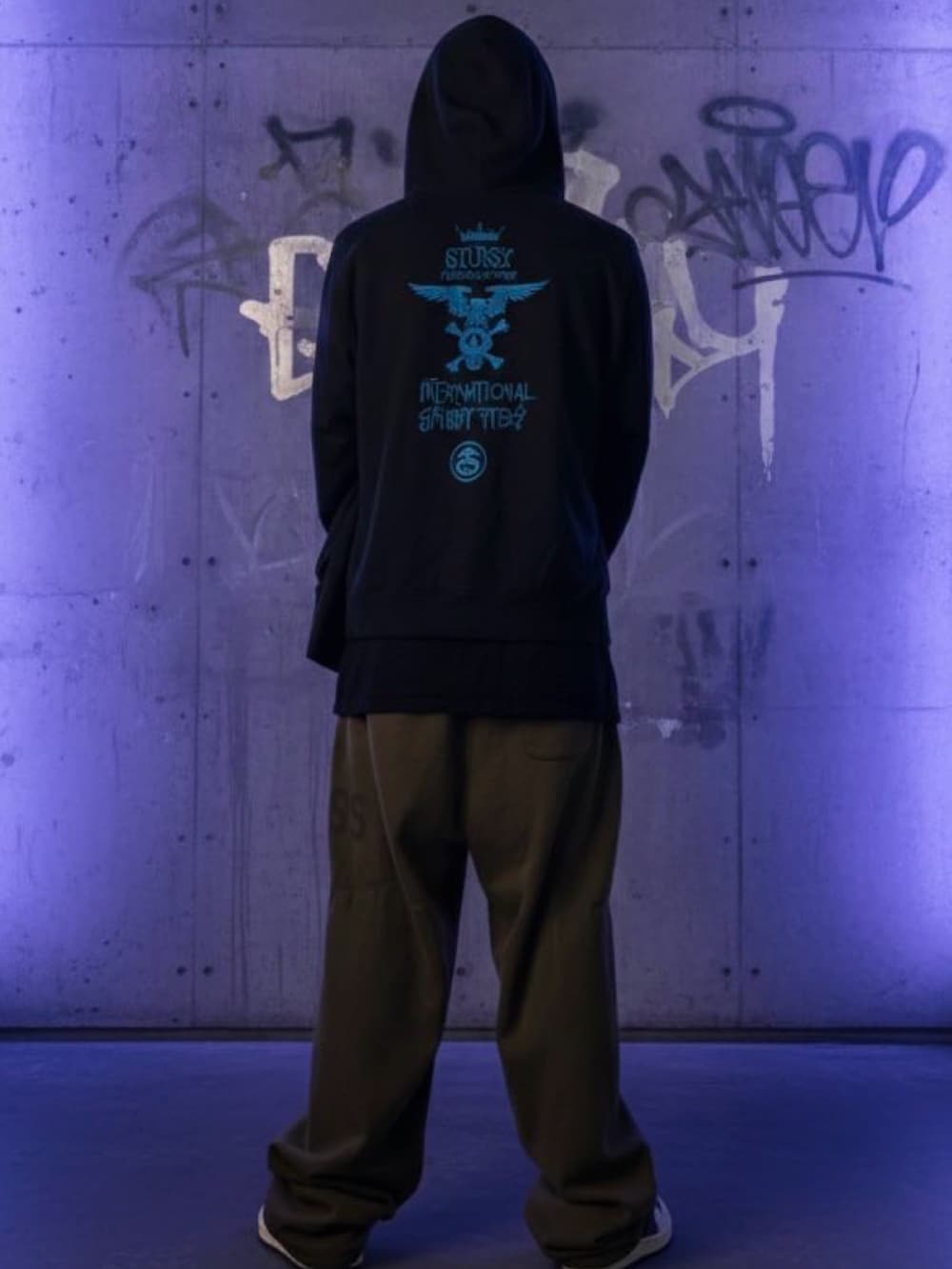 ブラック系のパーカー、ブラック系のTシャツ/カットソー、グリーン系のスウェットパンツを着用したメンズの冬コーディネートの2枚目の写真