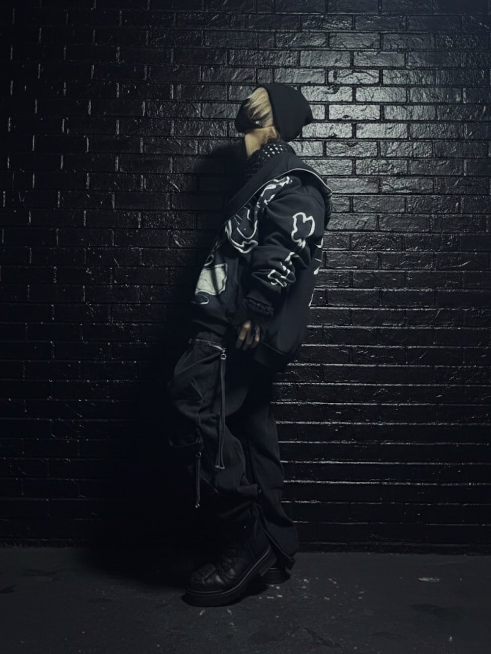 ブラック系のパーカー、ブラック系のカーゴパンツ、ブラック系のブーツを着用したメンズの冬コーディネートの2枚目の写真