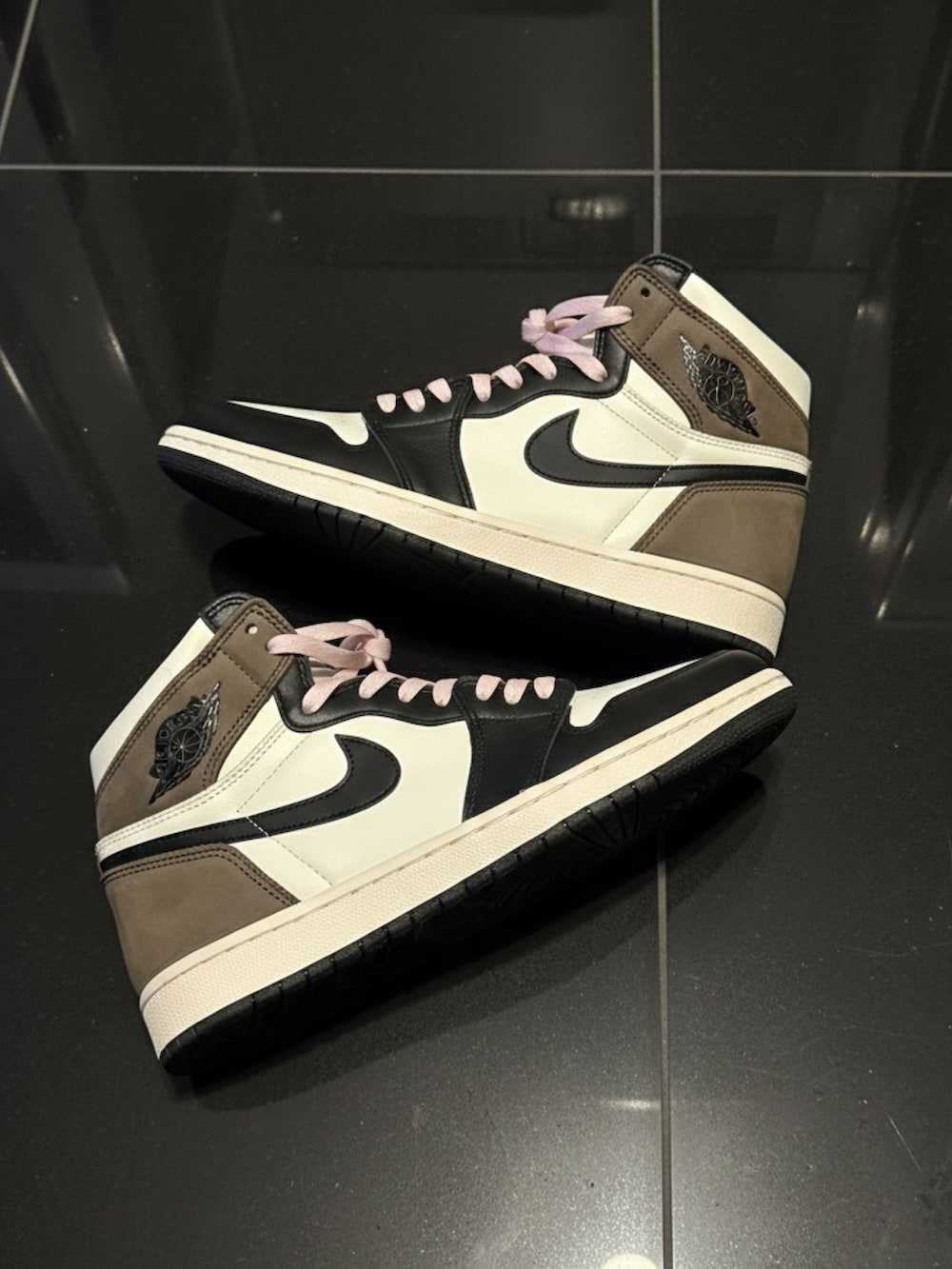 ピンク系のニット/セーター、ブラック系のデニムパンツ、ブラウン系のスニーカーを着用したメンズの冬コーディネートの2枚目の写真