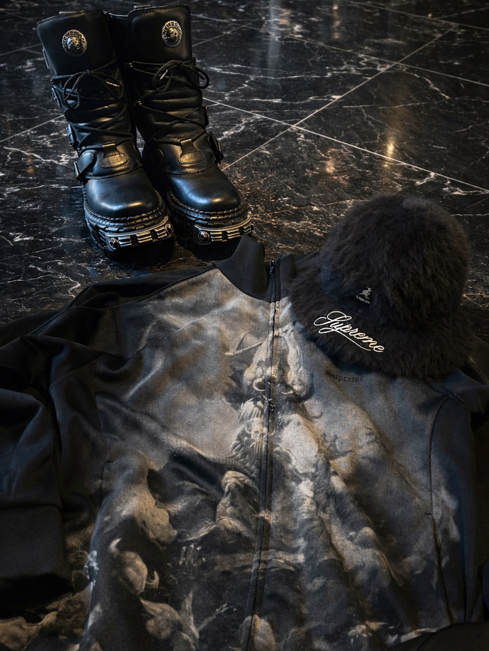 ブラック系のその他アウター、ブラック系のブーツ、ブラック系のハットを着用したメンズの冬コーディネートの2枚目の写真