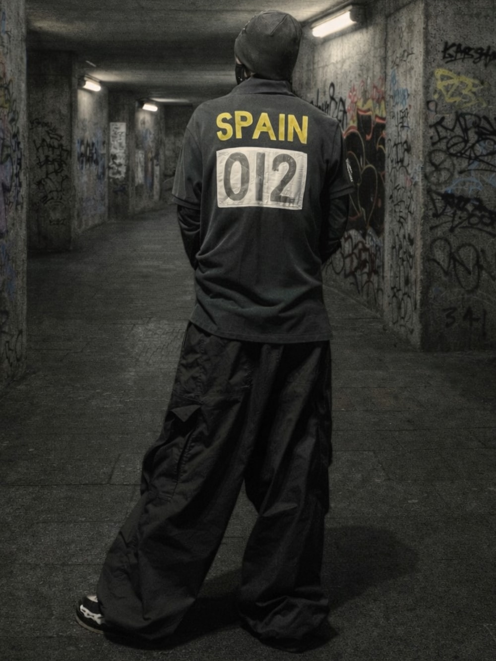 ブラック系のポロシャツ、ブラック系のスニーカーを着用したメンズの春コーディネートの2枚目の写真