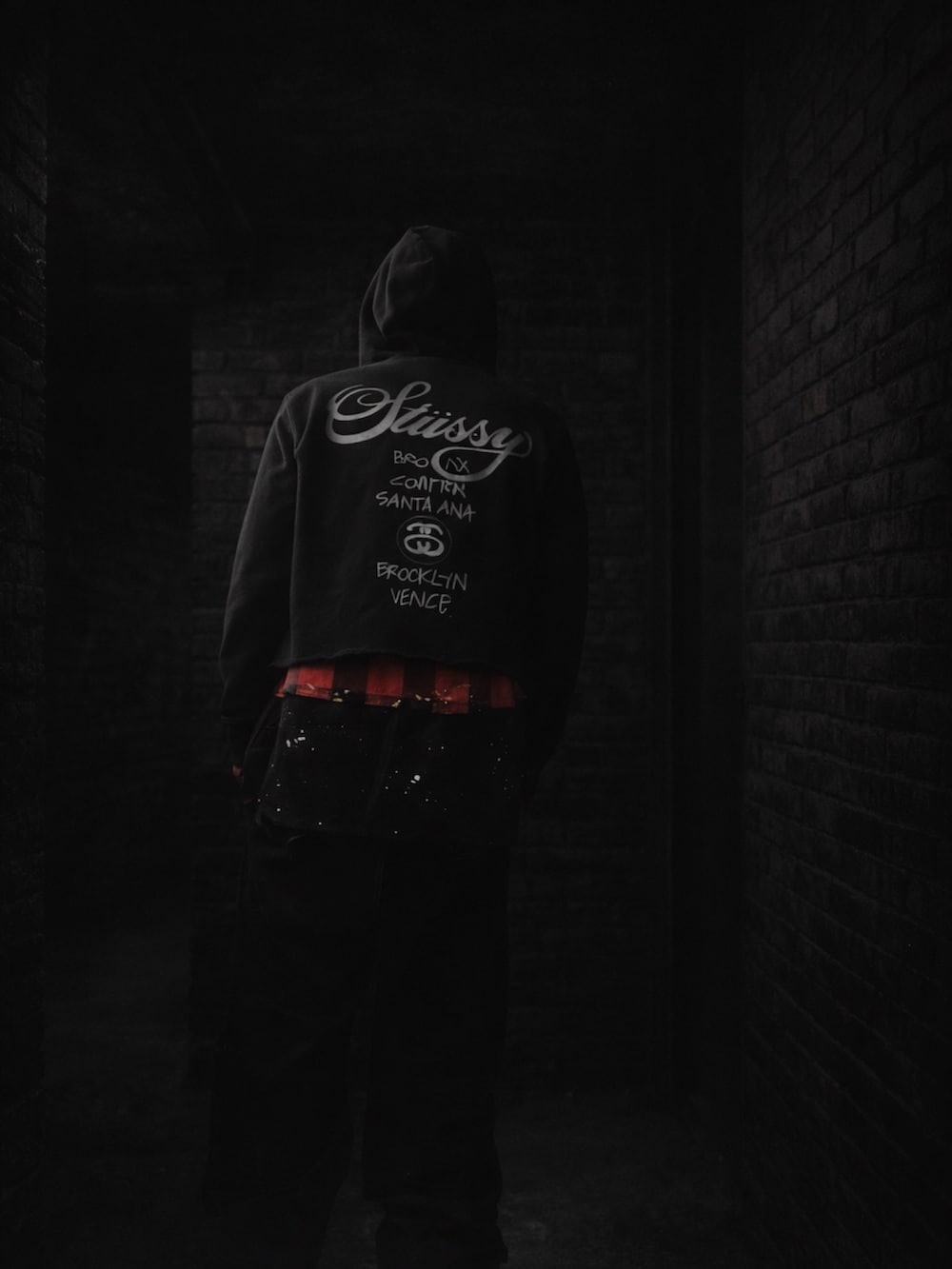 ブラック系のパーカー、レッド系のシャツ/ブラウス、ブラック系のカーゴパンツを着用したメンズの冬コーディネートの2枚目の写真