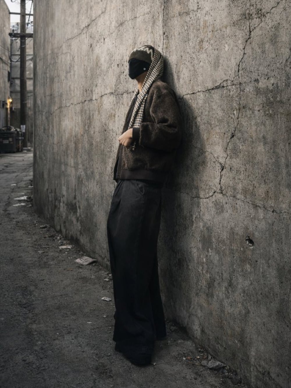 ブラック系のデニムパンツ、ブラウン系のカーディガン/ボレロ、ブラック系のスニーカーを着用したメンズの冬コーディネートの2枚目の写真