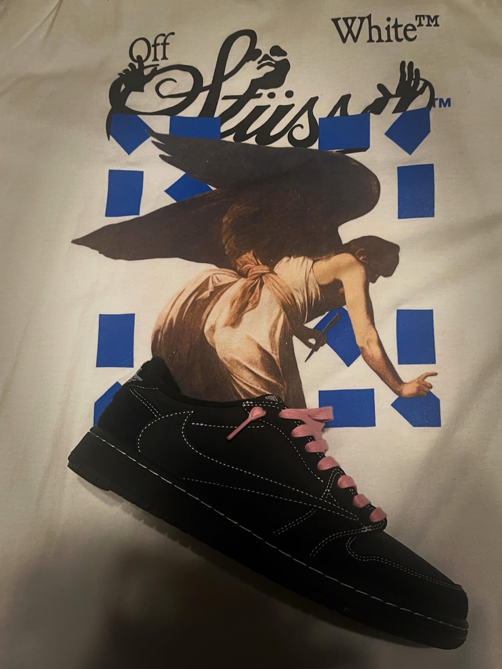 ホワイト系のTシャツ/カットソー、ピンク系のチノパンツ、ブラック系のスニーカーを着用したメンズの春コーディネートの2枚目の写真