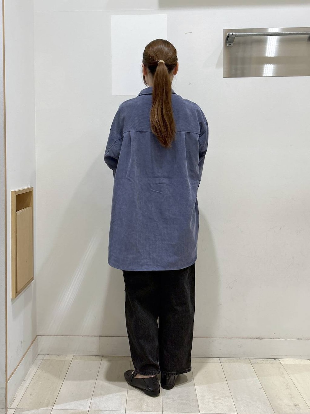 ブラック系のローファー、ブラック系のショルダーバッグ、ブラック系のデニムパンツを着用したレディースの秋コーディネートの4枚目の写真