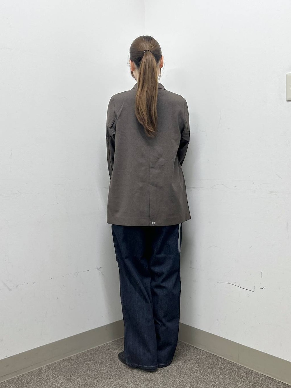 ブラック系のローファー、ブラウン系のテーラードジャケット、ブルー系のデニムパンツを着用したレディースの秋コーディネートの4枚目の写真