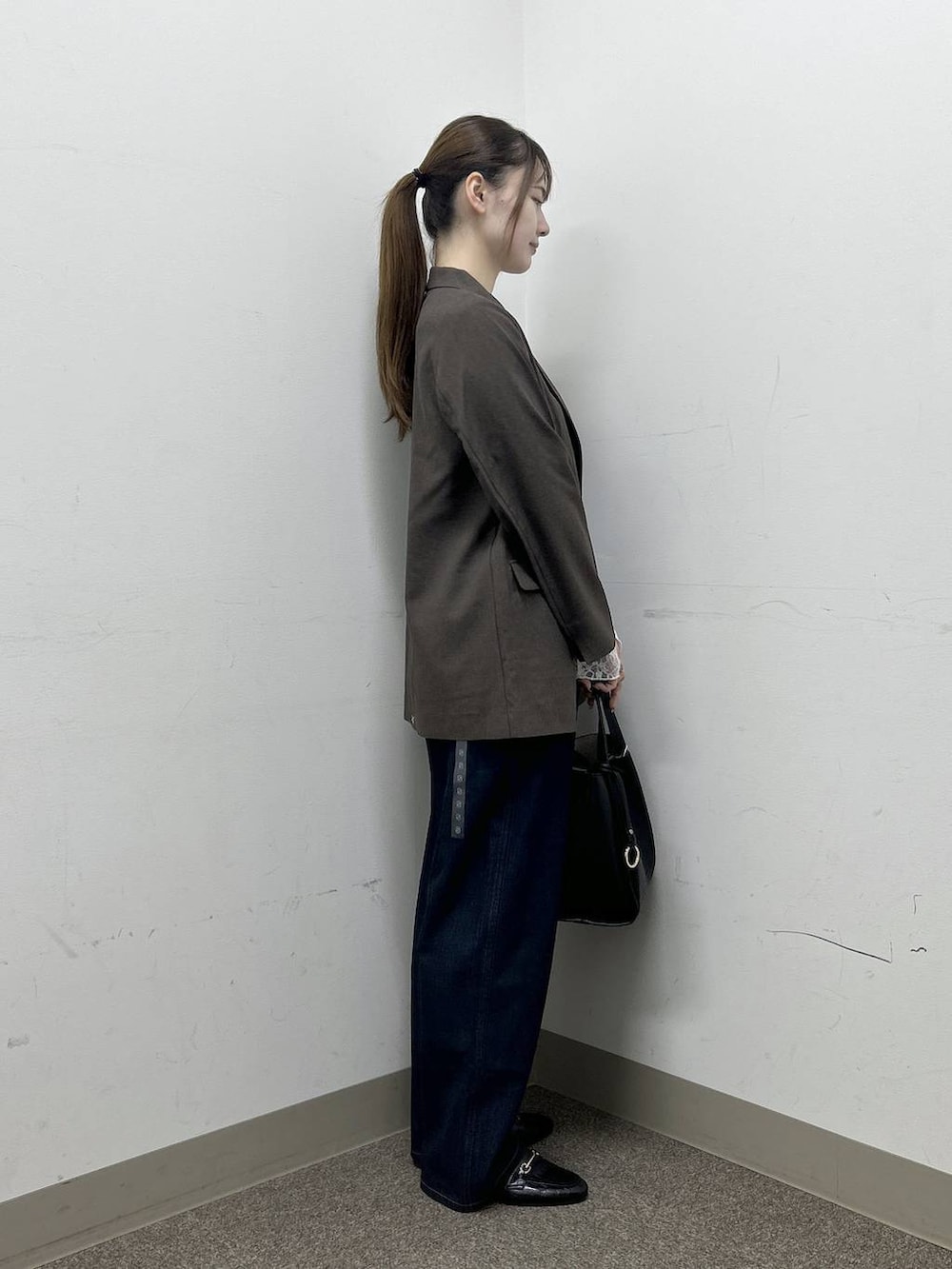 ブラック系のローファー、ブラウン系のテーラードジャケット、ブルー系のデニムパンツを着用したレディースの秋コーディネートの5枚目の写真