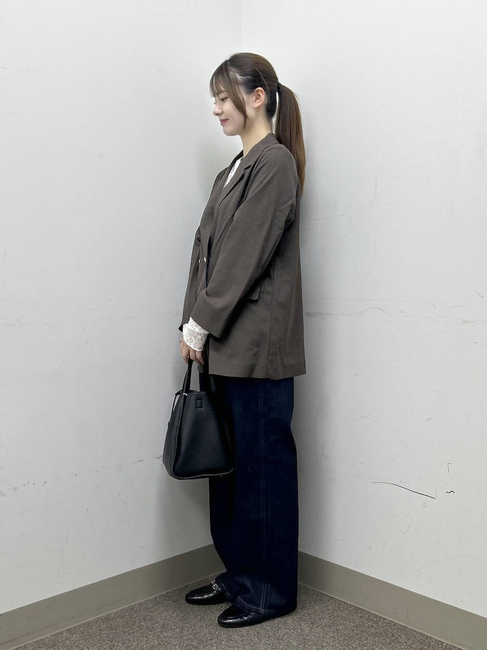 ブラック系のローファー、ブラウン系のテーラードジャケット、ブルー系のデニムパンツを着用したレディースの秋コーディネートの3枚目の写真