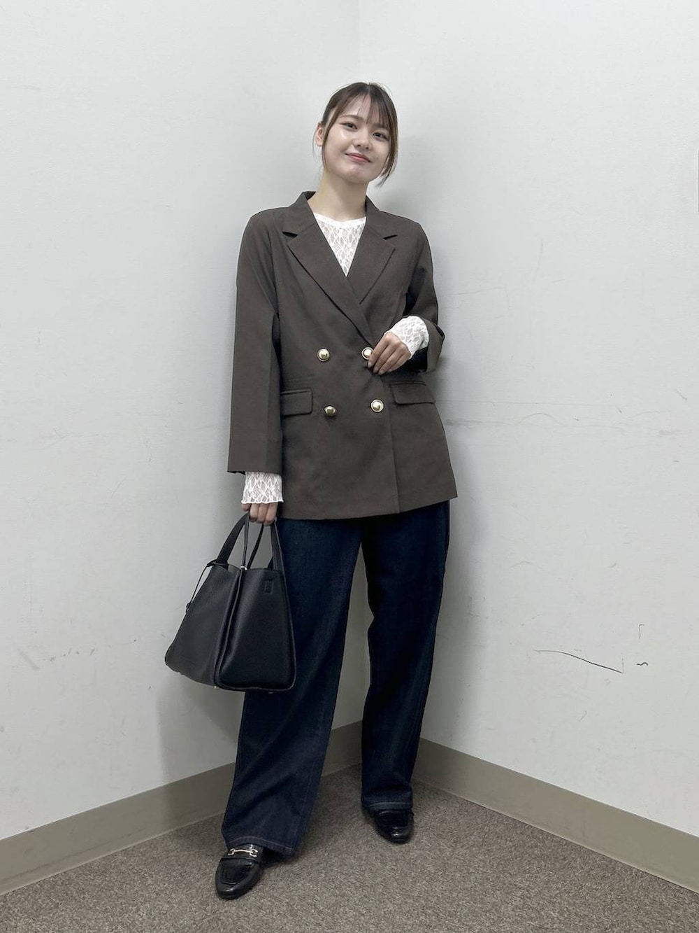 ブラック系のローファー、ブラウン系のテーラードジャケット、ブルー系のデニムパンツを着用したレディースの秋コーディネートの6枚目の写真