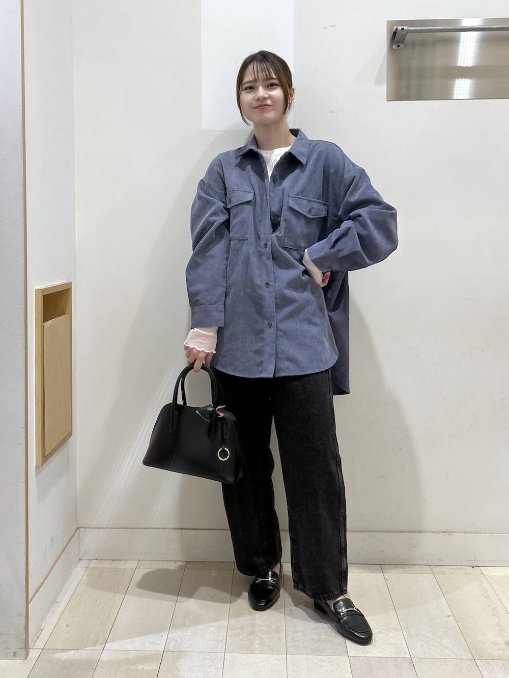 ブラック系のローファー、ブラック系のショルダーバッグ、ブラック系のデニムパンツを着用したレディースの秋コーディネートの2枚目の写真