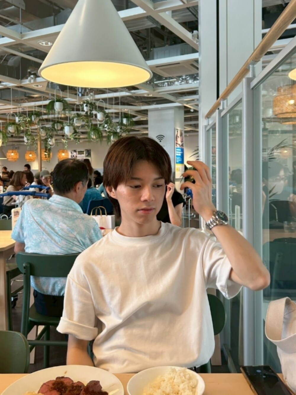 グリーン系のスニーカー、ホワイト系のTシャツ/カットソー、ブラウン系のデニムパンツを着用したメンズの秋コーディネートの3枚目の写真