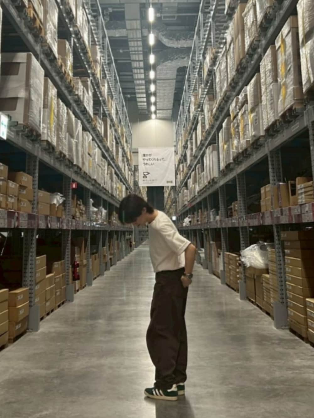 グリーン系のスニーカー、ホワイト系のTシャツ/カットソー、ブラウン系のデニムパンツを着用したメンズの秋コーディネートの2枚目の写真