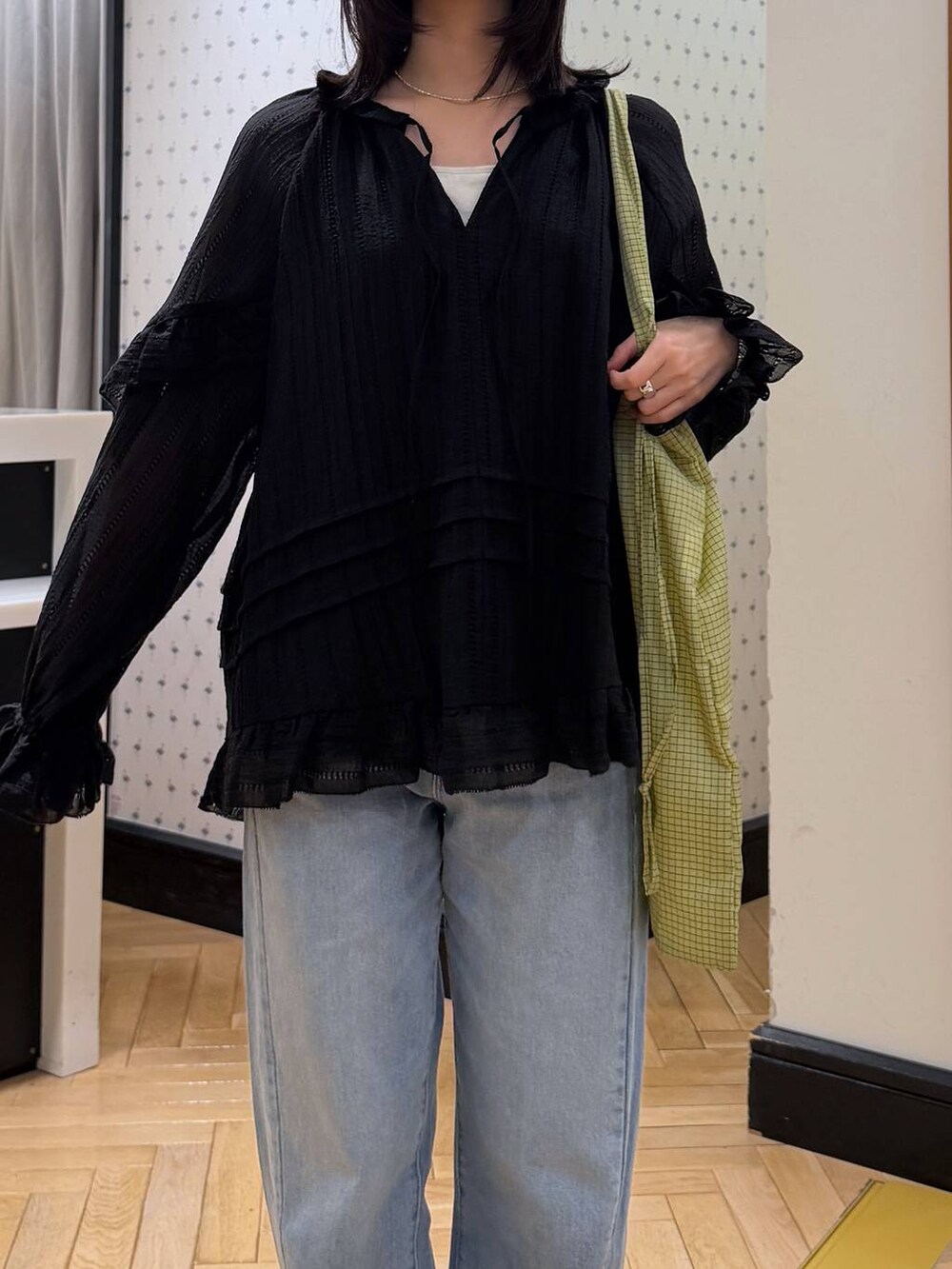 ブルー系のデニムパンツ、ブラック系のシャツ/ブラウス、グリーン系のトートバッグを着用したレディースの春コーディネートの5枚目の写真