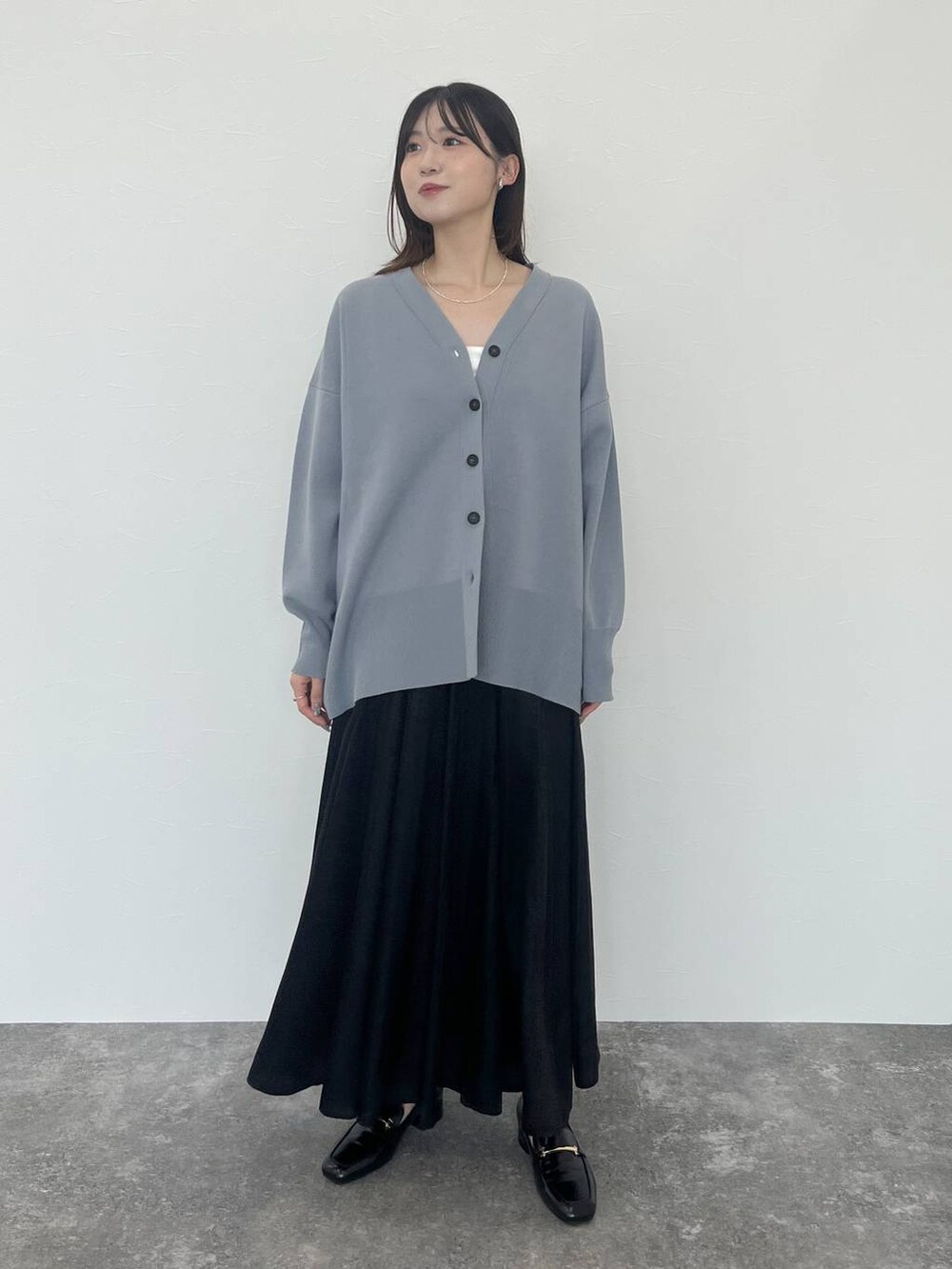 ブルー系のカーディガン/ボレロ、ブラック系のローファー、シルバー系のネックレスを着用したレディースの秋コーディネートの3枚目の写真