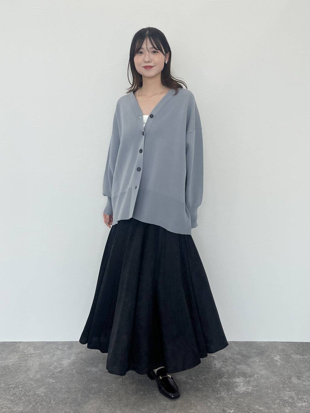 ブルー系のカーディガン/ボレロ、ブラック系のローファー、シルバー系のネックレスを着用したレディースの秋コーディネートの6枚目の写真