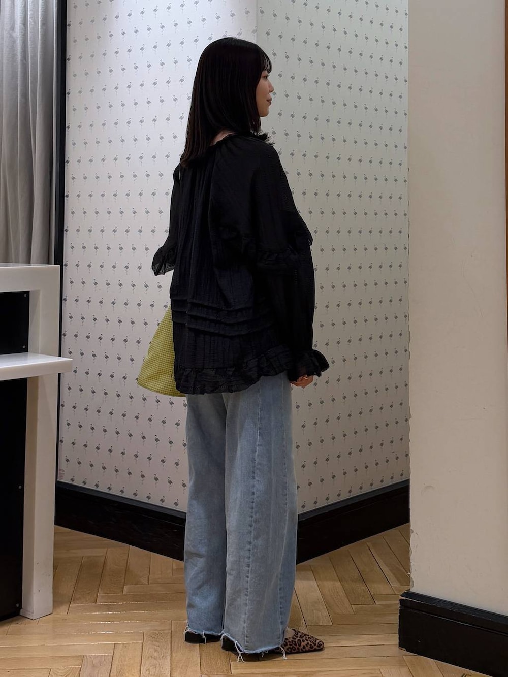 ブルー系のデニムパンツ、ブラック系のシャツ/ブラウス、グリーン系のトートバッグを着用したレディースの春コーディネートの3枚目の写真