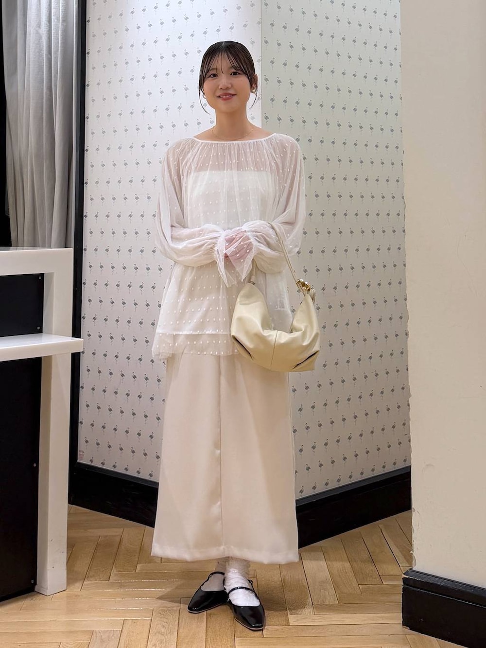 ホワイト系のシャツ/ブラウス、ブラック系のパンプス、ホワイト系のスカートを着用したレディースの冬コーディネートの2枚目の写真