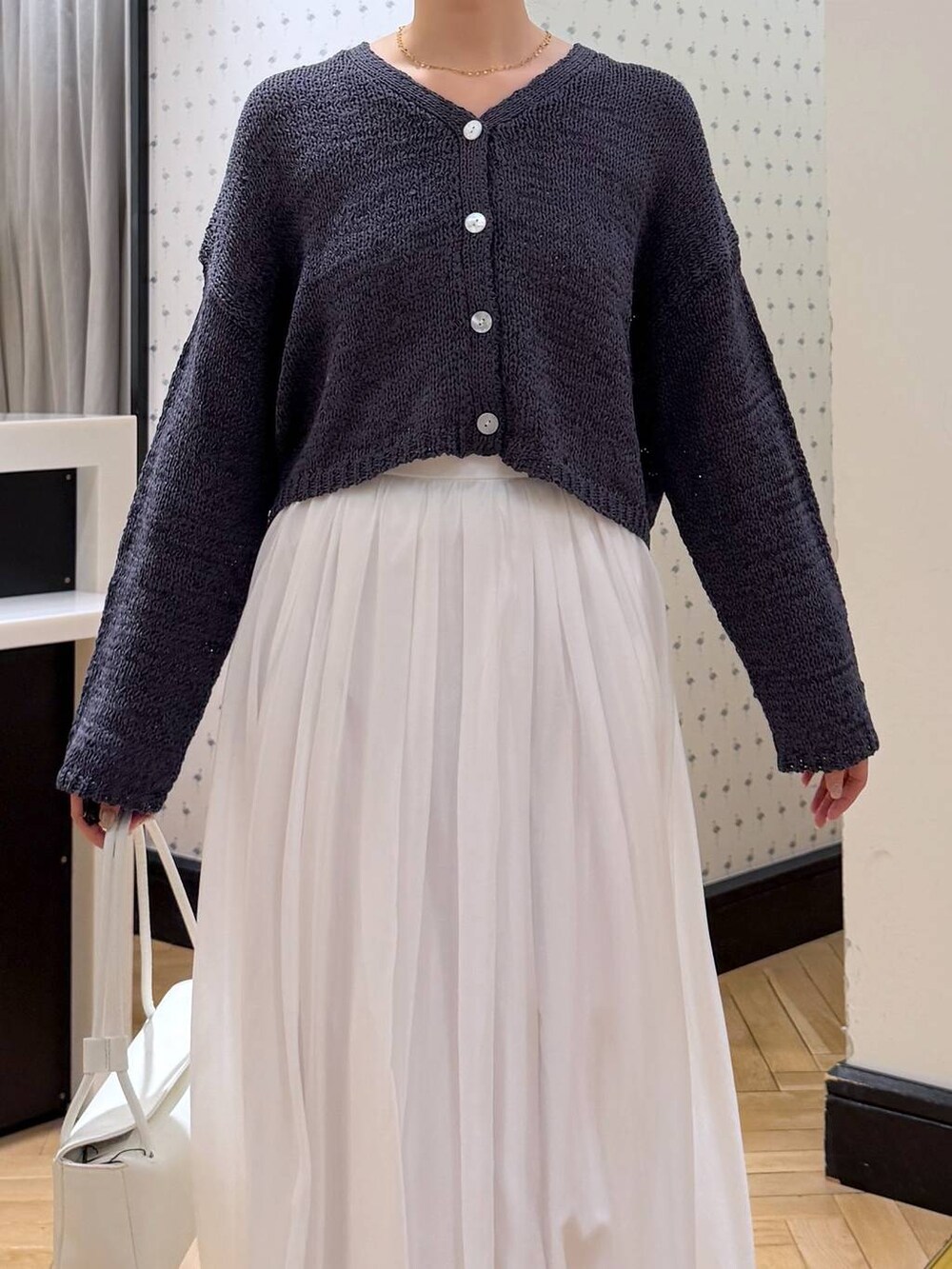 ホワイト系のスカート、ブラック系のローファー、ホワイト系のショルダーバッグを着用したレディースの冬コーディネートの5枚目の写真