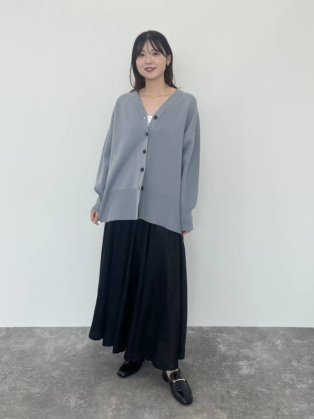 ブルー系のカーディガン/ボレロ、ブラック系のローファー、シルバー系のネックレスを着用したレディースの秋コーディネートの2枚目の写真