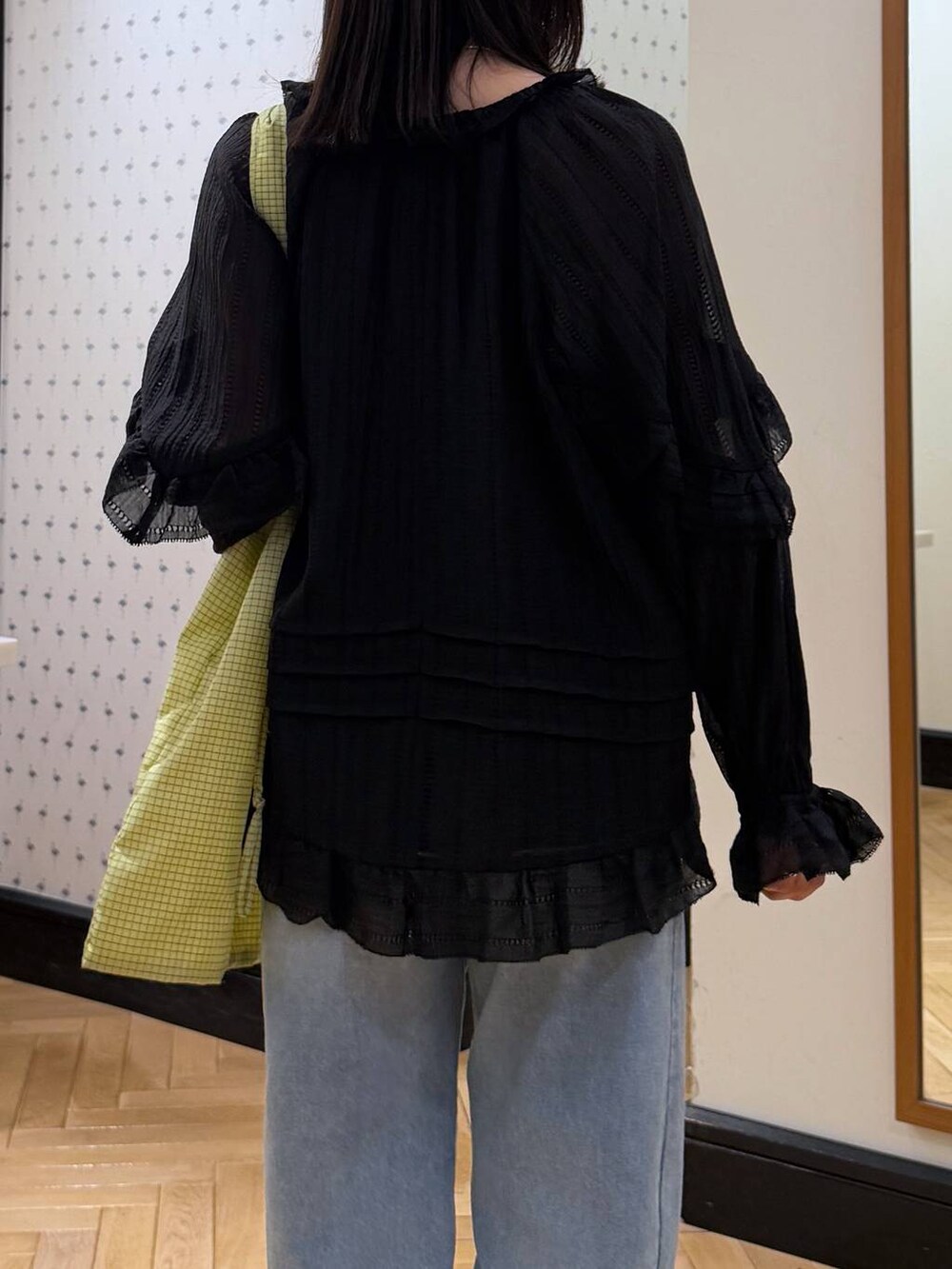 ブルー系のデニムパンツ、ブラック系のシャツ/ブラウス、グリーン系のトートバッグを着用したレディースの春コーディネートの6枚目の写真