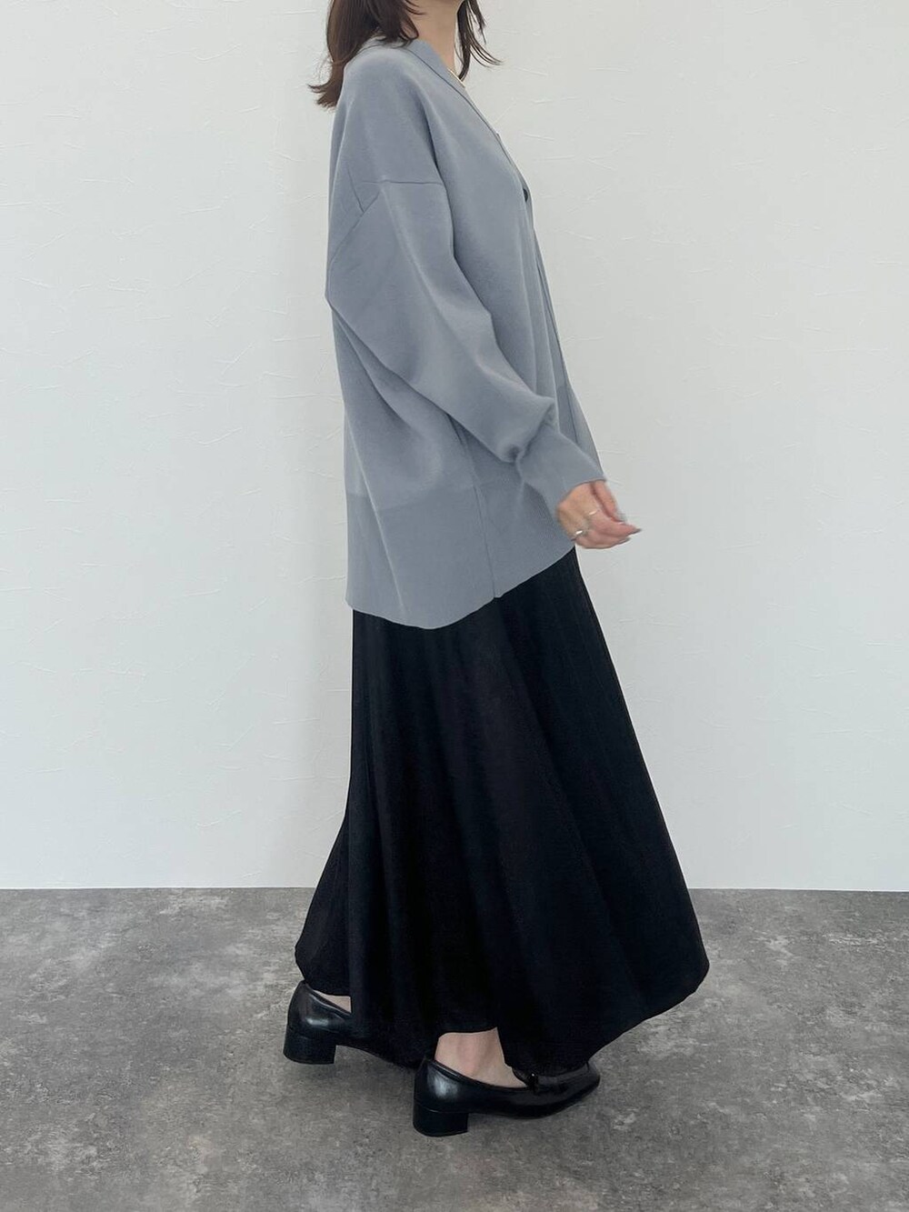 ブルー系のカーディガン/ボレロ、ブラック系のローファー、シルバー系のネックレスを着用したレディースの秋コーディネートの5枚目の写真