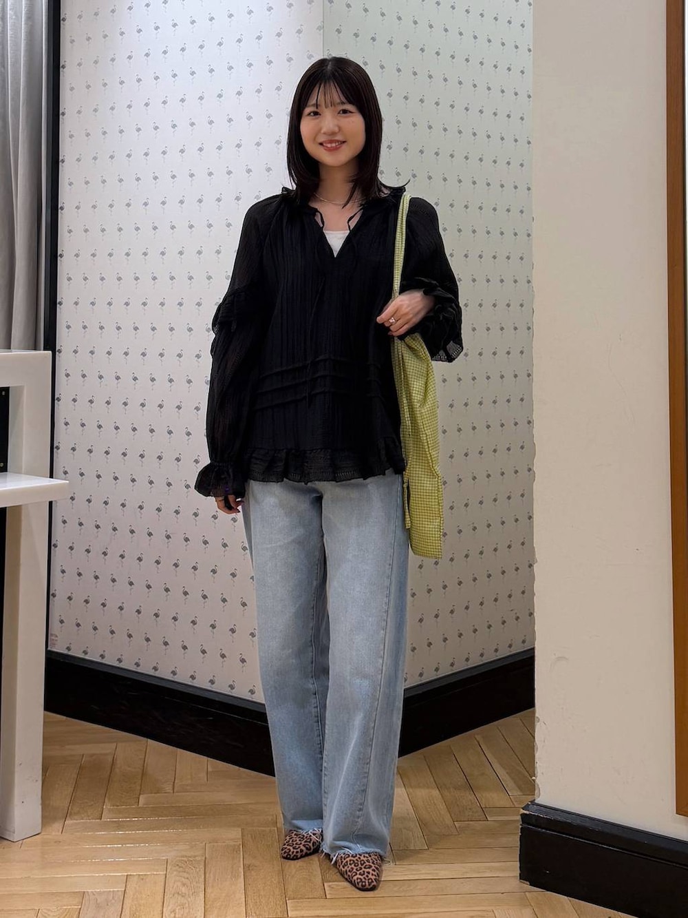 ブルー系のデニムパンツ、ブラック系のシャツ/ブラウス、グリーン系のトートバッグを着用したレディースの春コーディネートの4枚目の写真