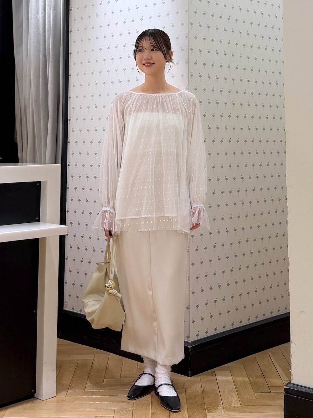 ホワイト系のシャツ/ブラウス、ブラック系のパンプス、ホワイト系のスカートを着用したレディースの冬コーディネートの4枚目の写真