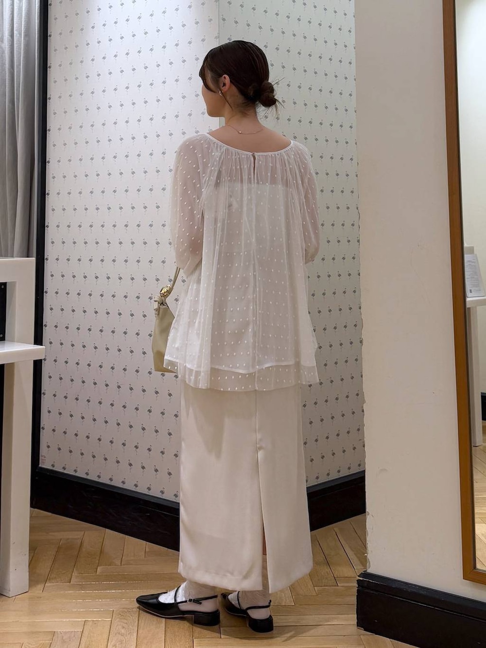 ホワイト系のシャツ/ブラウス、ブラック系のパンプス、ホワイト系のスカートを着用したレディースの冬コーディネートの3枚目の写真