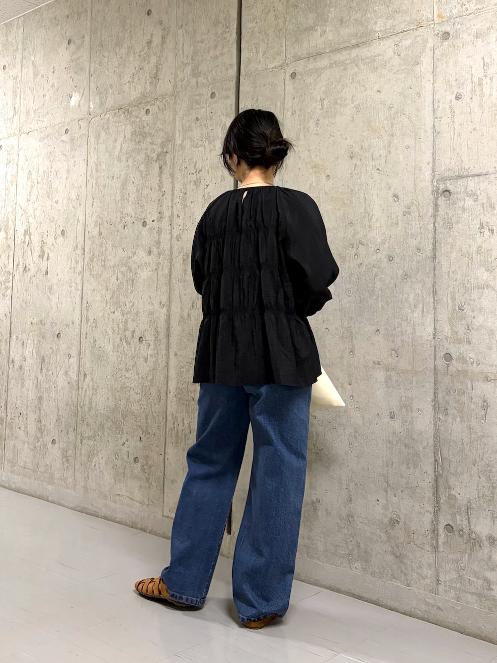 ブラック系のシャツ/ブラウス、ブルー系のデニムパンツ、ブラウン系のサンダルを着用したレディースの春コーディネートの2枚目の写真