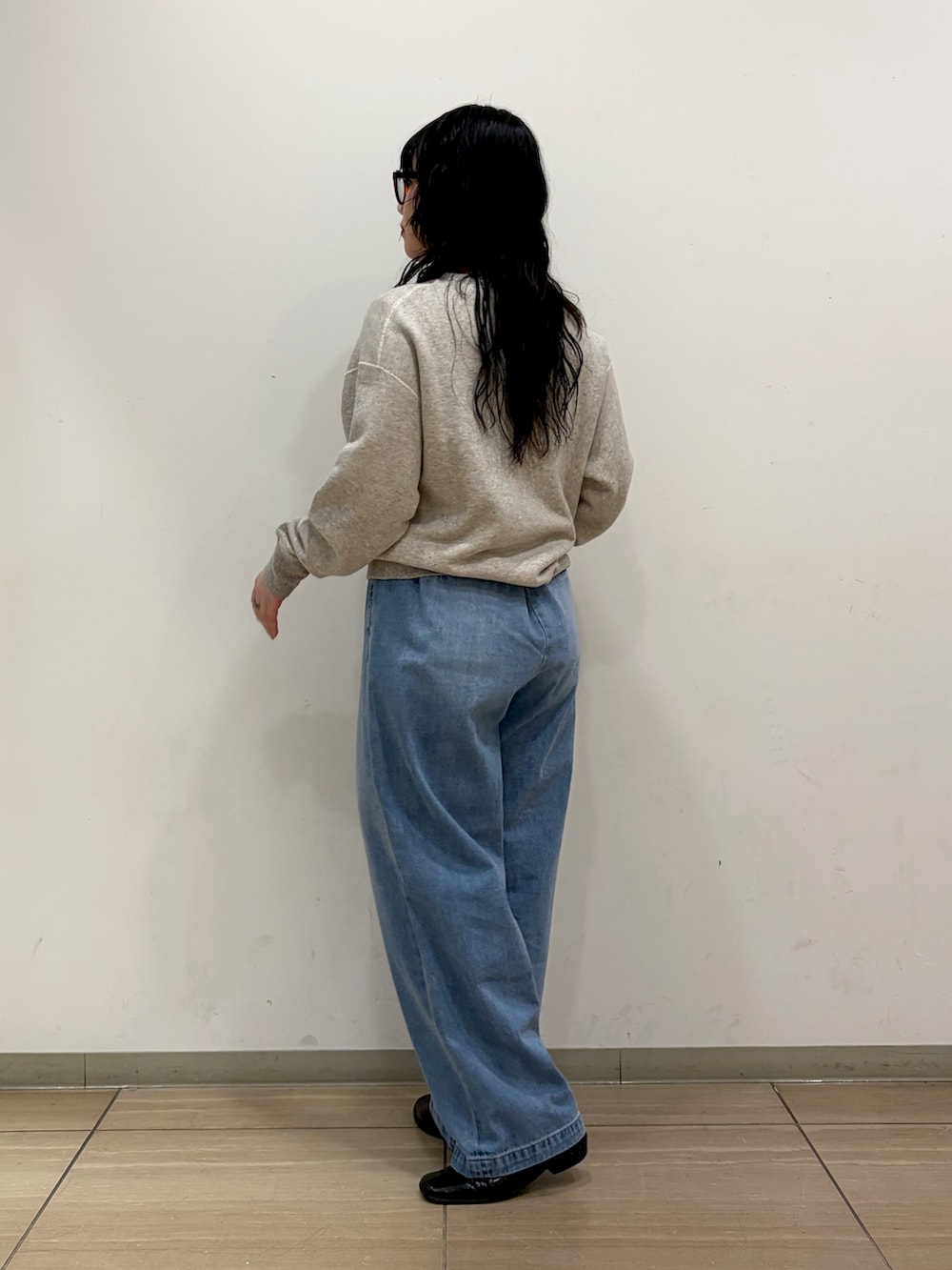 グレー系のスウェット、ブルー系のデニムパンツを着用したレディースの冬コーディネートの2枚目の写真