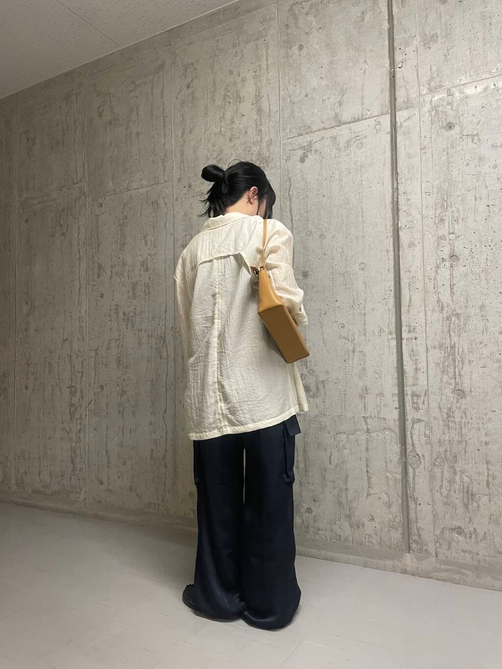 グレー系のタンクトップ、イエロー系のショルダーバッグ、ホワイト系のその他アウターを着用したレディースの春コーディネートの3枚目の写真