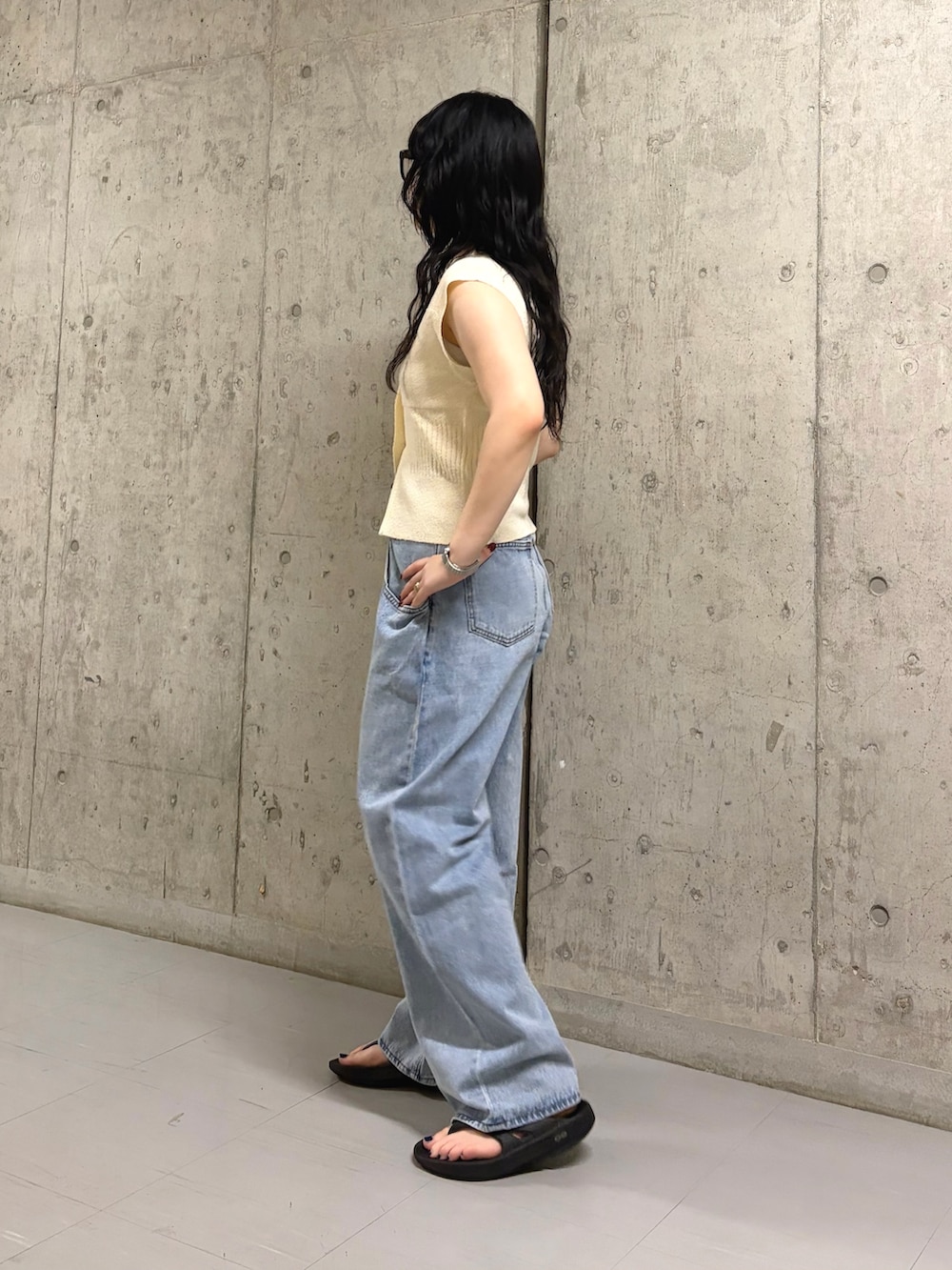 ホワイト系のニット/セーター、ブルー系のデニムパンツを着用したレディースの春コーディネートの2枚目の写真
