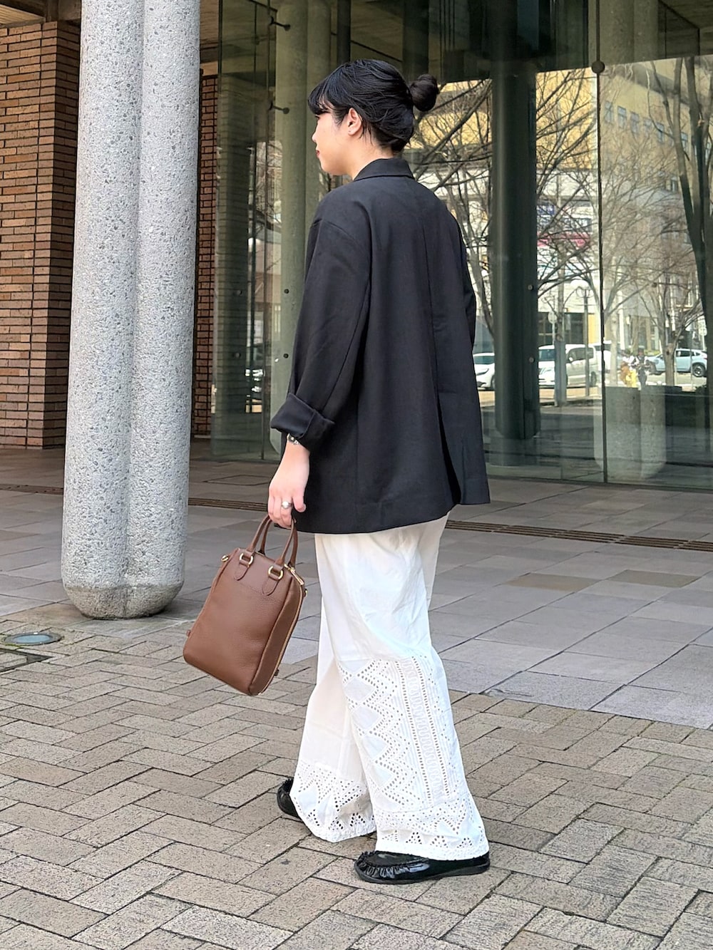 グレー系のその他アウター、ホワイト系のその他パンツ、ブラウン系のボストンバッグを着用したレディースの春コーディネートの2枚目の写真