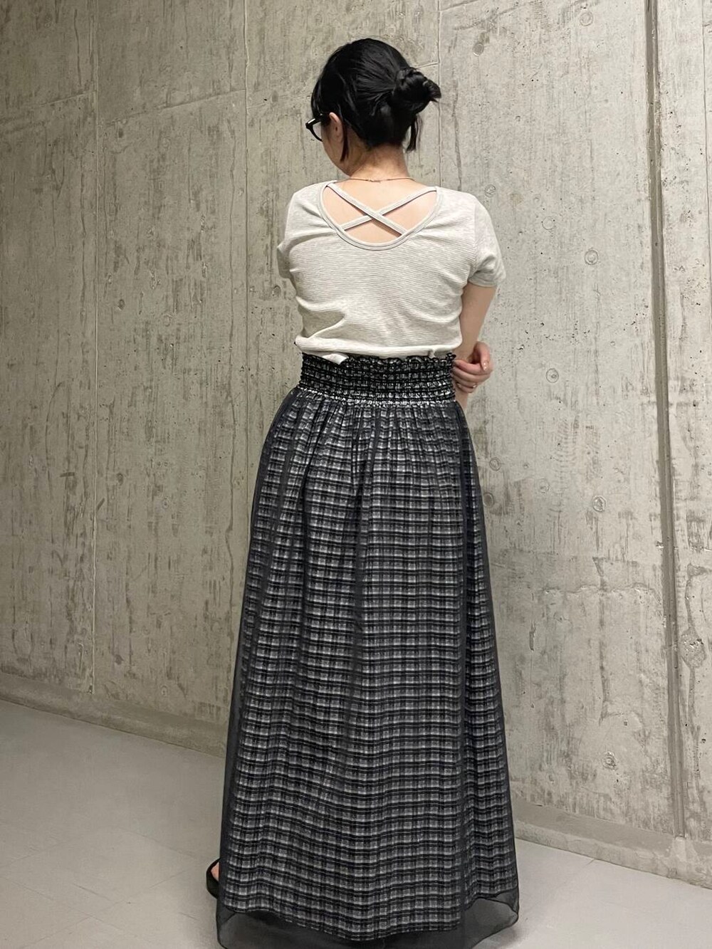 ブラック系のスカート、グレー系のTシャツ/カットソーを着用したレディースの夏コーディネートの2枚目の写真