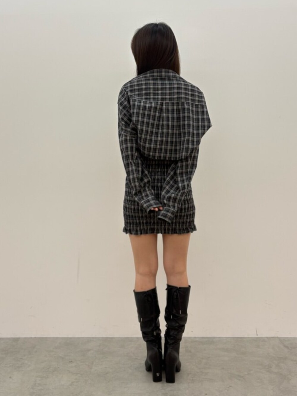 ブラック系のワンピース、ブラック系のブーツを着用したレディースの秋コーディネートの3枚目の写真