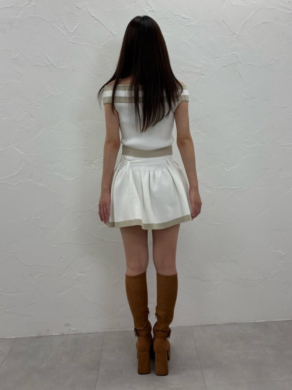 ホワイト系のワンピース、ブラウン系のブーツを着用したレディースの夏コーディネートの4枚目の写真