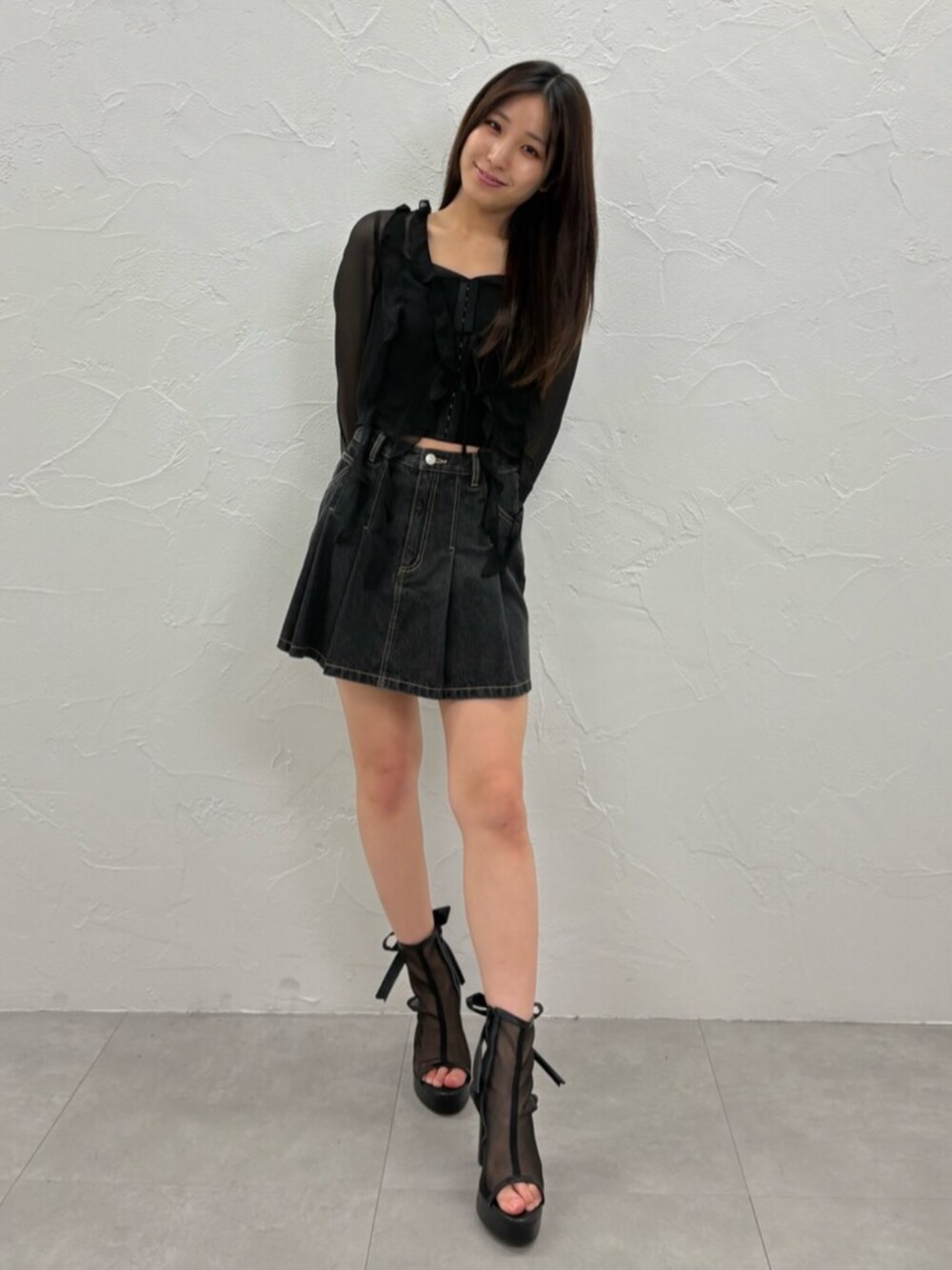 ブラック系のデニムスカート、ブラック系のカーディガン/ボレロ、ブラック系のキャミソールを着用したレディースの夏コーディネートの2枚目の写真