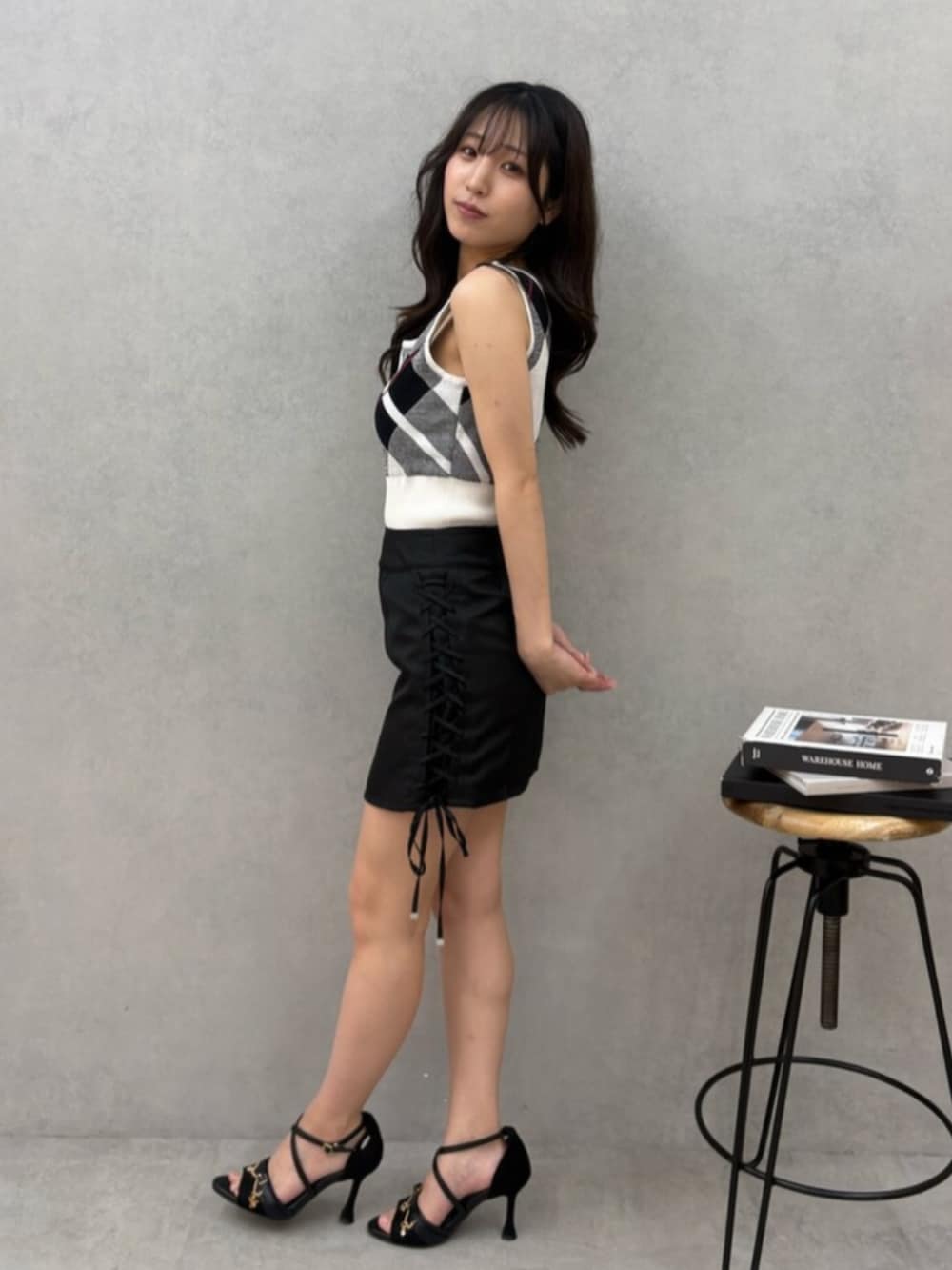 ブラック系のサンダル、ホワイト系のニット/セーター、ブラック系のスカートを着用したレディースの夏コーディネートの2枚目の写真