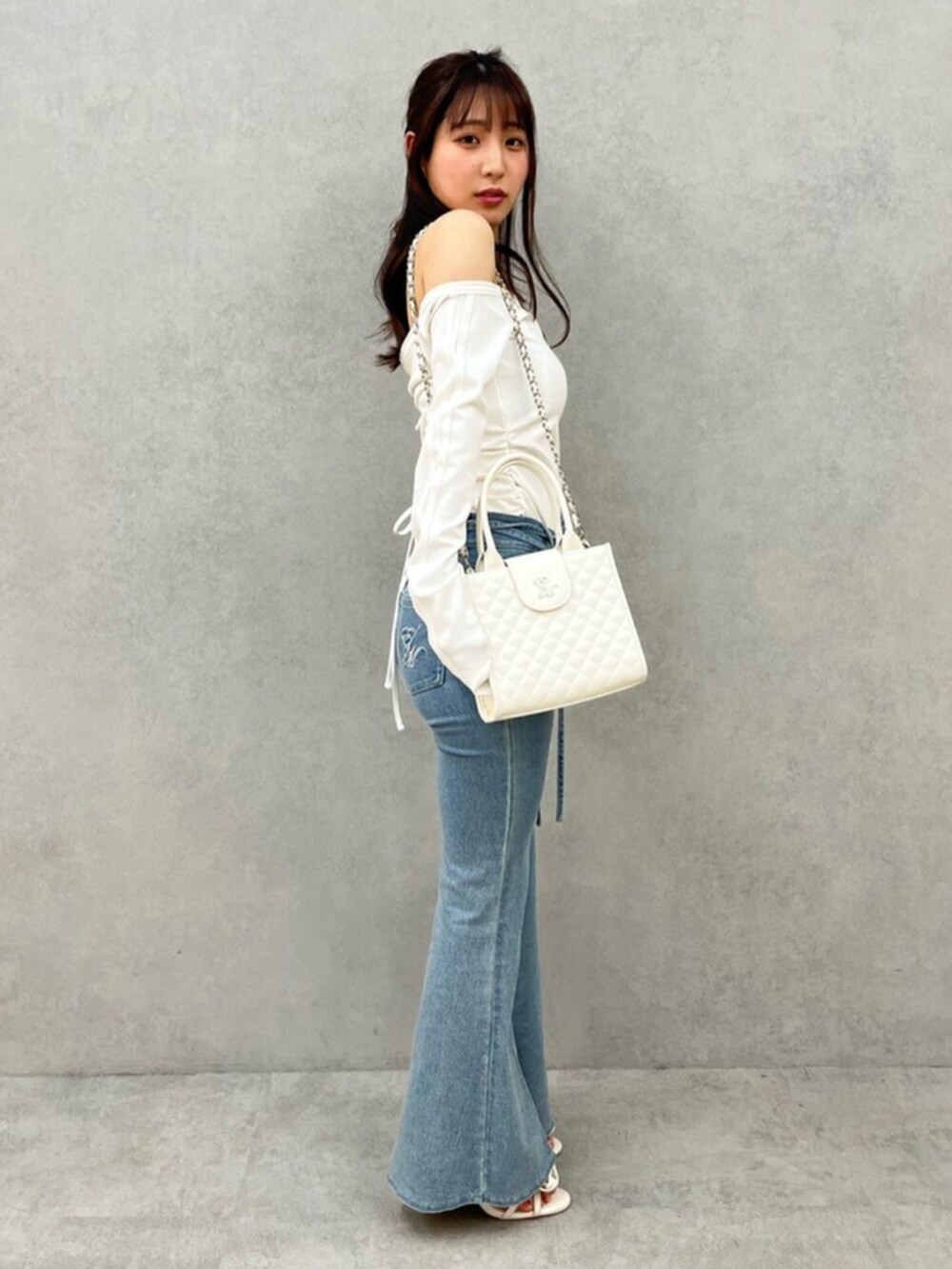 ブルー系のデニムパンツ、ホワイト系のTシャツ/カットソー、ホワイト系のサンダルを着用したレディースの春コーディネートの2枚目の写真
