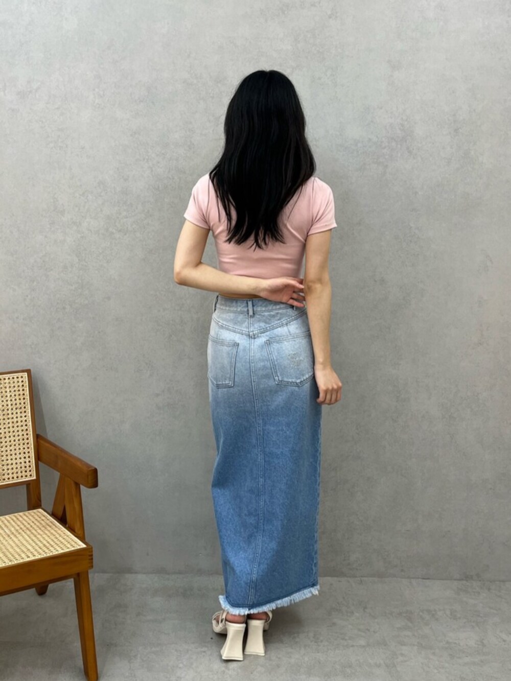 ピンク系のTシャツ/カットソー、ブルー系のデニムスカート、ホワイト系のサンダルを着用したレディースの夏コーディネートの3枚目の写真